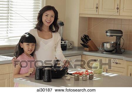 Mother and daughter making food together View Large Photo Image Stock Photo - Mother and daughter making food together. Fotosearch