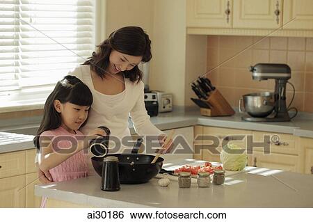 Mother and daughter making food together View Large Photo Image Stock Photograph - Mother and daughter making food together. Fotosearch