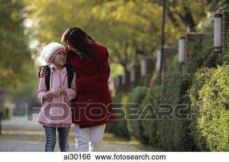 Mother and daughter walking down street together laughing View Large Photo Image Stock Photograph - Mother and daughter walking down street together laughing. Fotosearch