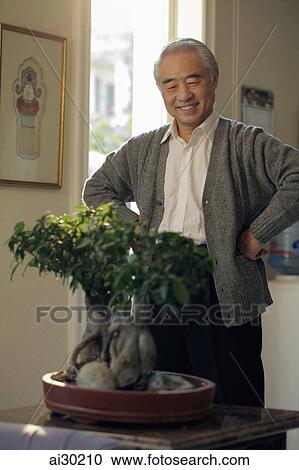 Older man looking at his bonsai tree View Large Photo Image Stock Image - Older man looking at his bonsai tree. Fotosearch