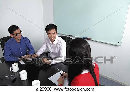 Overhead view of three people having a meeting View Large Photo Image Stock Image - Overhead view of three people having a meeting. Fotosearch