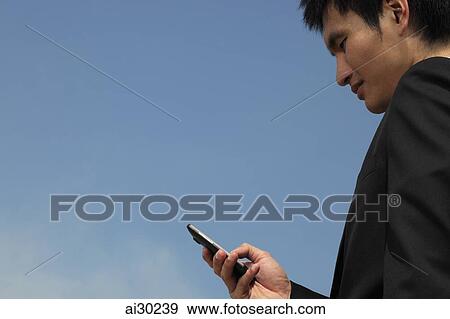 Profile of young man looking at phone, airplane in background View Large Photo Image Stock Photo - Profile of young man looking at phone, airplane in background. Fotosearch