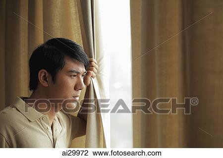 Profile of young man standing at the window pulling the drapes back View Large Photo Image Stock Image - Profile of young man standing at the window pulling the drapes back. Fotosearch