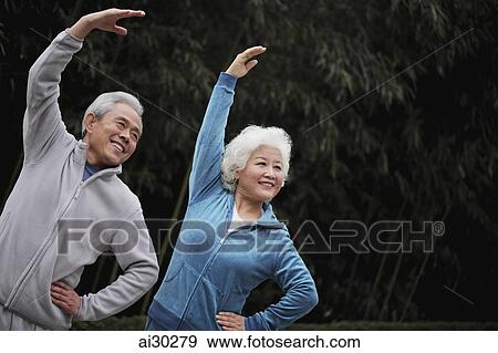 Stock Photo - Senior man and woman stretching together. Fotosearch