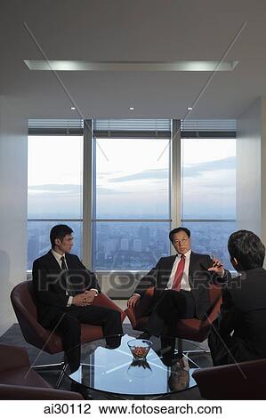 Three businessmen talking in office View Large Photo Image Stock Image - Three businessmen talking in office. Fotosearch