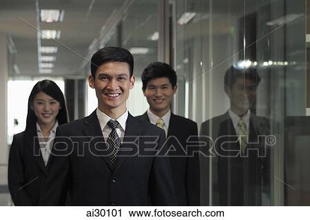 Three businesspeople standing in hallway View Large Photo Image Stock Image - Three businesspeople standing in hallway. Fotosearch