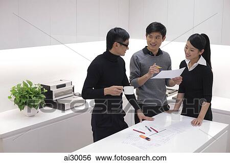 Three people working together in modern office View Large Photo Image Stock Photograph - Three people working together in modern office. Fotosearch