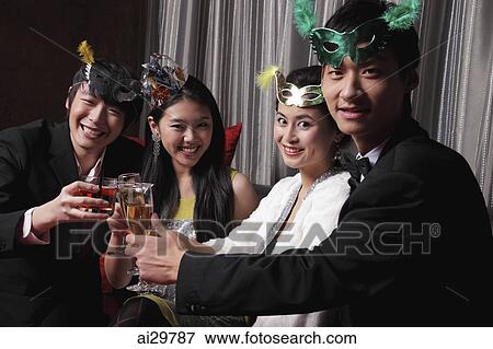 Stock Photo - Two couples toasting each other at a party. Fotosearch