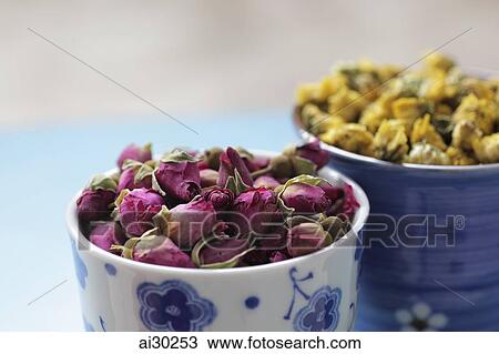 Stock Image - Two cups of dried rose and chrysanthemum flowers for tea. Fotosearch
