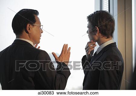 Two men talking in front of window View Large Photo Image Stock Image - Two men talking in front of window. Fotosearch