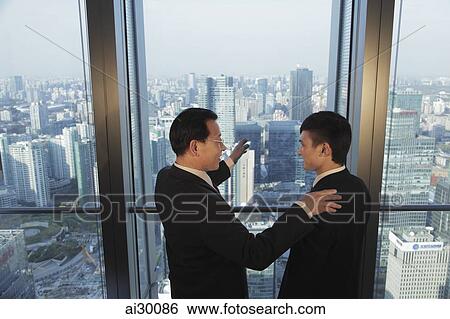 Two men talking in front of window with a view of the city of Beijing View Large Photo Image Stock Photograph - Two men talking in front of window with a view of the city of Beijing. Fotosearch