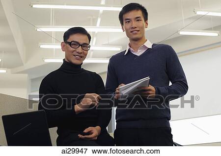 Two men working together in an office View Large Photo Image Stock Photo - Two men working together in an office. Fotosearch