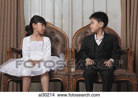 Young boy and girl dressed in nice clothes looking at each other View Large Photo Image Picture - Young boy and girl dressed in nice clothes looking at each other. Fotosearch