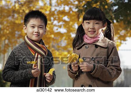 Young boy and girl holding Autumn leaves outdoor View Large Photo Image Stock Image - Young boy and girl holding Autumn leaves outdoor. Fotosearch