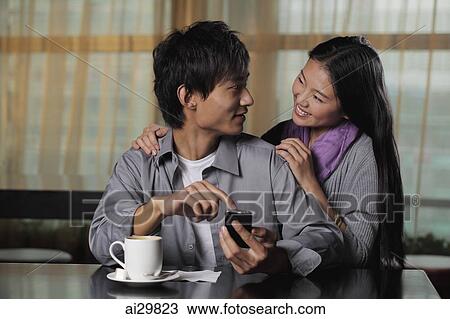 Young couple at cafe looking at each other View Large Photo Image Stock Image - Young couple at cafe looking at each other. Fotosearch