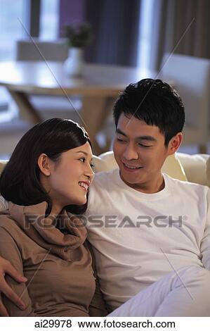 Young couple at home looking at each other and smiling View Large Photo Image Stock Photo - Young couple at home looking at each other and smiling. Fotosearch