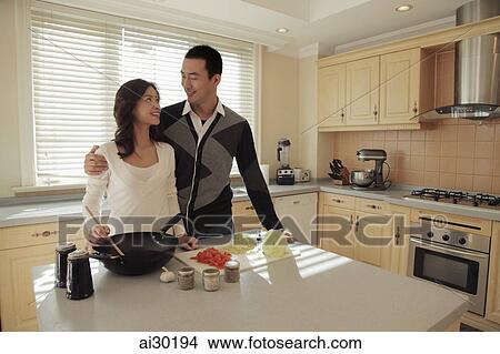 Young couple cooking together in their kitchen View Large Photo Image Picture - Young couple cooking together in their kitchen. Fotosearch