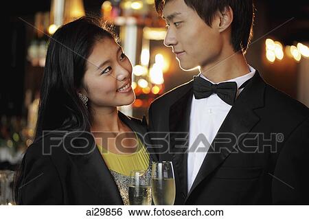 Young couple dressed up at night, looking at each other View Large Photo Image Stock Photograph - Young couple dressed up at night, looking at each other. Fotosearch
