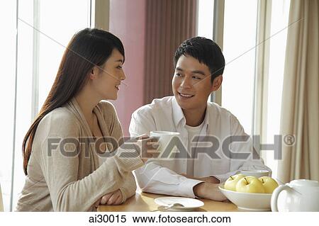 Young couple drinking coffee together in their home View Large Photo Image Stock Photography - Young couple drinking coffee together in their home. Fotosearch