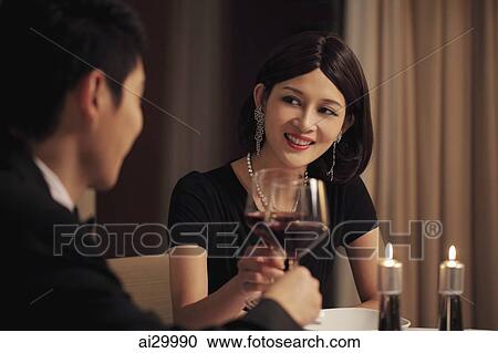 Stock Image - Young couple having a candle lit dinner. Fotosearch