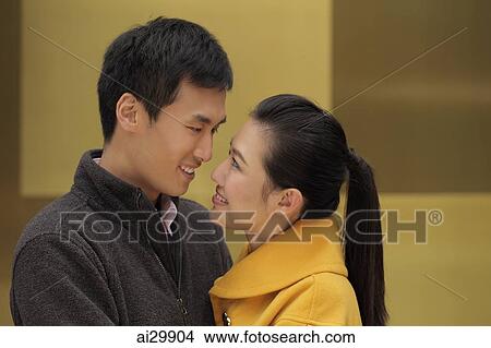 Young couple looking at each other and smiling View Large Photo Image Picture - Young couple looking at each other and smiling. Fotosearch