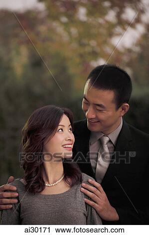 Young couple looking at each other and smiling View Large Photo Image Stock Image - Young couple looking at each other and smiling. Fotosearch