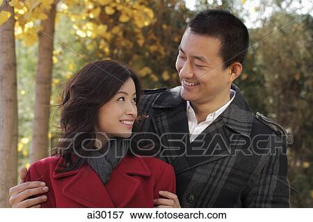 Young couple looking at each other out doors View Large Photo Image Stock Photo - Young couple looking at each other out doors. Fotosearch
