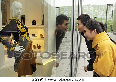 Young couple looking in shop window while shopping View Large Photo Image Picture - Young couple looking in shop window while shopping. Fotosearch