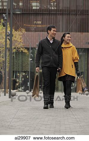 Young couple shopping together outdoors View Large Photo Image Stock Photo - Young couple shopping together outdoors. Fotosearch