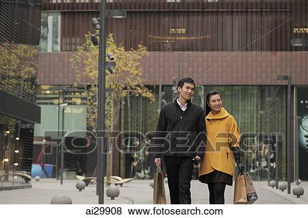 Young couple shopping together outdoors View Large Photo Image Stock Photo - Young couple shopping together outdoors. Fotosearch
