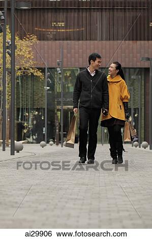 Stock Photograph - Young couple shopping together outdoors. Fotosearch