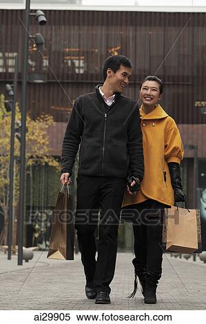 Young couple shopping together outdoors View Large Photo Image Stock Photography - Young couple shopping together outdoors. Fotosearch