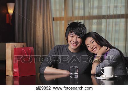 Young couple sitting in restaurant together View Large Photo Image Stock Image - Young couple sitting in restaurant together. Fotosearch