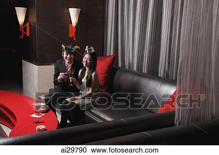 Stock Image - Young couple sitting together at a club. Fotosearch