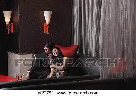 Young couple sitting together at a club View Large Photo Image Stock Image - Young couple sitting together at a club. Fotosearch