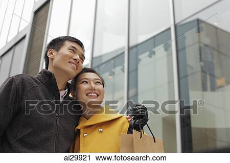 Young couple smiling and looking up View Large Photo Image Stock Image - Young couple smiling and looking up. Fotosearch