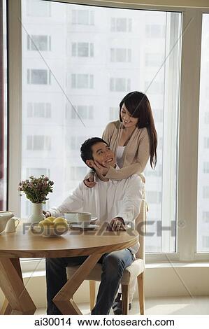 Young couple smiling at each other in their condo View Large Photo Image Picture - Young couple smiling at each other in their condo. Fotosearch
