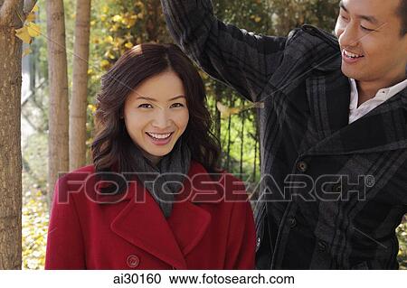 Young couple smiling together oudoors View Large Photo Image Stock Image - Young couple smiling together oudoors. Fotosearch
