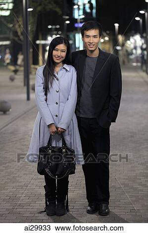 Young couple standing on street at night. View Large Photo Image Stock Image - Young couple standing on street at night.. Fotosearch