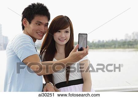 Young couple talking photo of eachother outdoor View Large Photo Image Stock Image - Young couple talking photo of eachother outdoor. Fotosearch