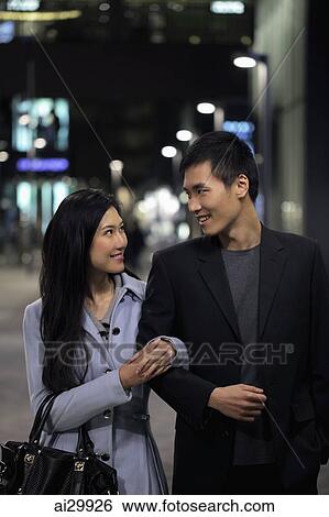 Young couple walking together on the street at night View Large Photo Image Stock Photograph - Young couple walking together on the street at night. Fotosearch