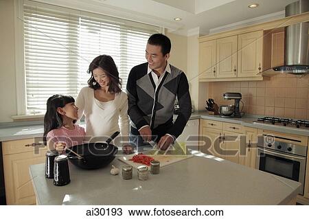 Young family cooking together in the kitchen View Large Photo Image Stock Image - Young family cooking together in the kitchen. Fotosearch