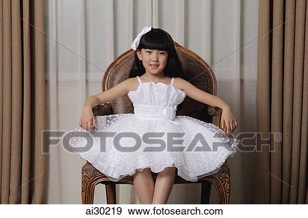 Young girl dress up in white dress sitting in nice chair View Large Photo Image Stock Photo - Young girl dress up in white dress sitting in nice chair. Fotosearch