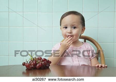 Young girl eating grapes View Large Photo Image Stock Photo - Young girl eating grapes. Fotosearch