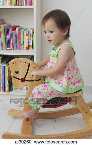Young girl riding rocking horse View Large Photo Image Stock Image - Young girl riding rocking horse. Fotosearch