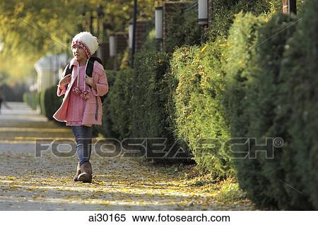 Young girl walking down sidewalk wearing pink coat, hat and backpack View Large Photo Image Stock Photography - Young girl walking down sidewalk wearing pink coat, hat and backpack. Fotosearch