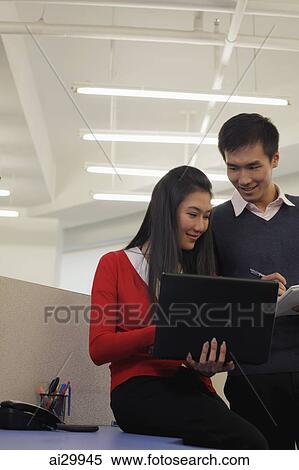 Young man and woman working together in an office View Large Photo Image Stock Photography - Young man and woman working together in an office. Fotosearch