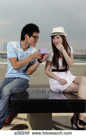 Young man giving present to young woman View Large Photo Image Stock Photo - Young man giving present to young woman. Fotosearch