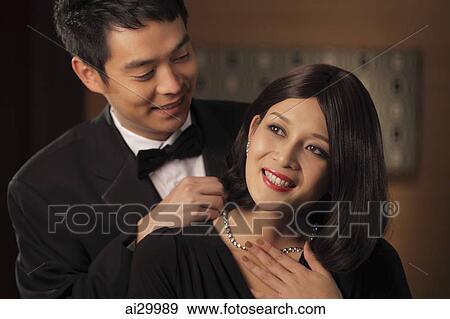 Young man putting a diamond necklace onto a woman View Large Photo Image Stock Photo - Young man putting a diamond necklace onto a woman. Fotosearch