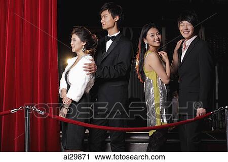 Young people standing behind red rope at night View Large Photo Image Stock Image - Young people standing behind red rope at night. Fotosearch